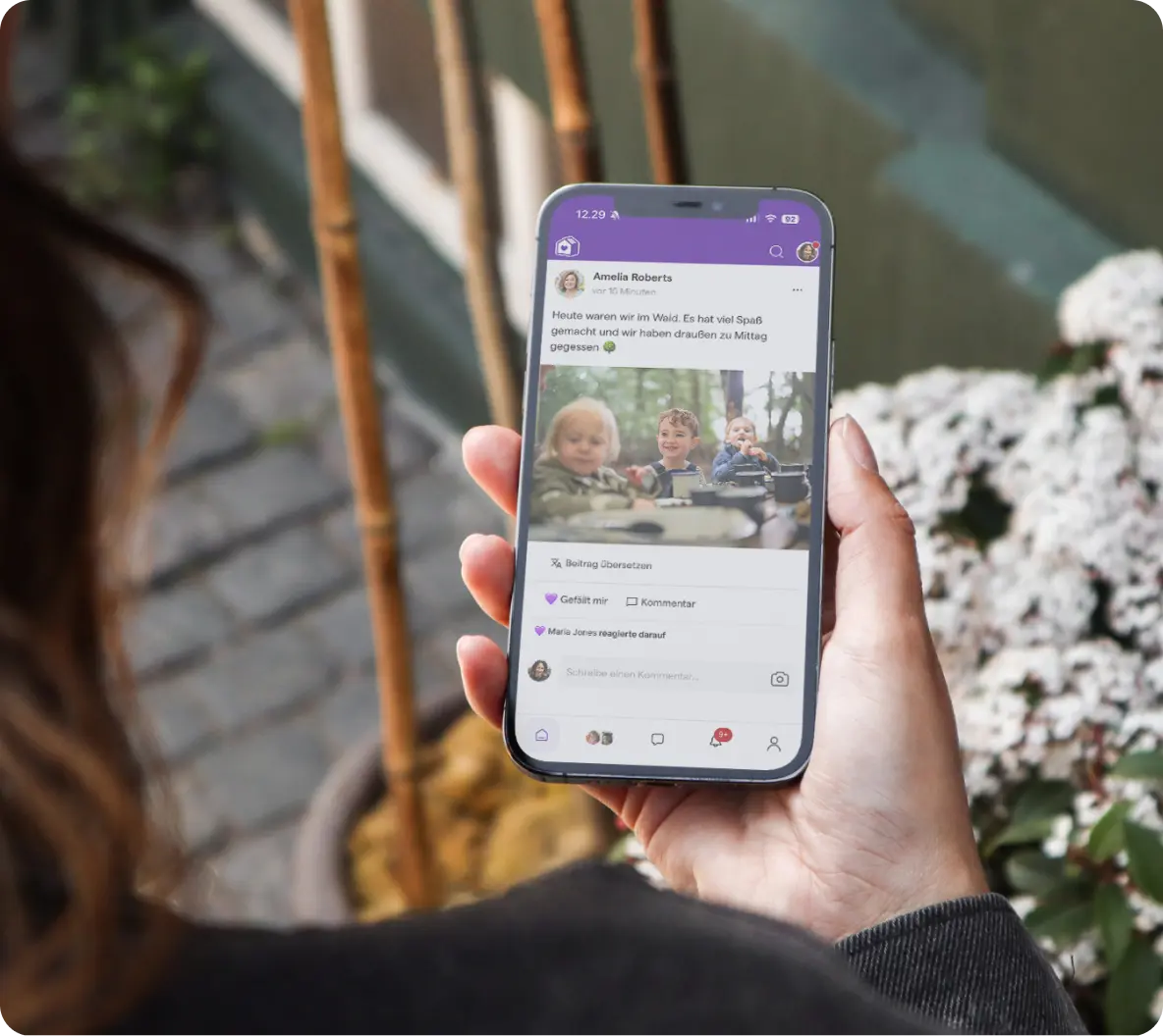 Die famly-App auf einem Smartphone mit Wochenbericht und Foto aus der Kita